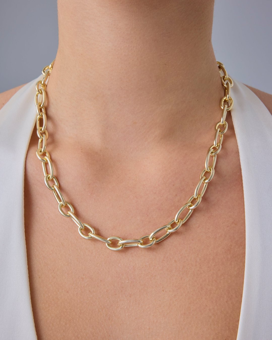 Gold-tone oval link chain worn at the collarbone