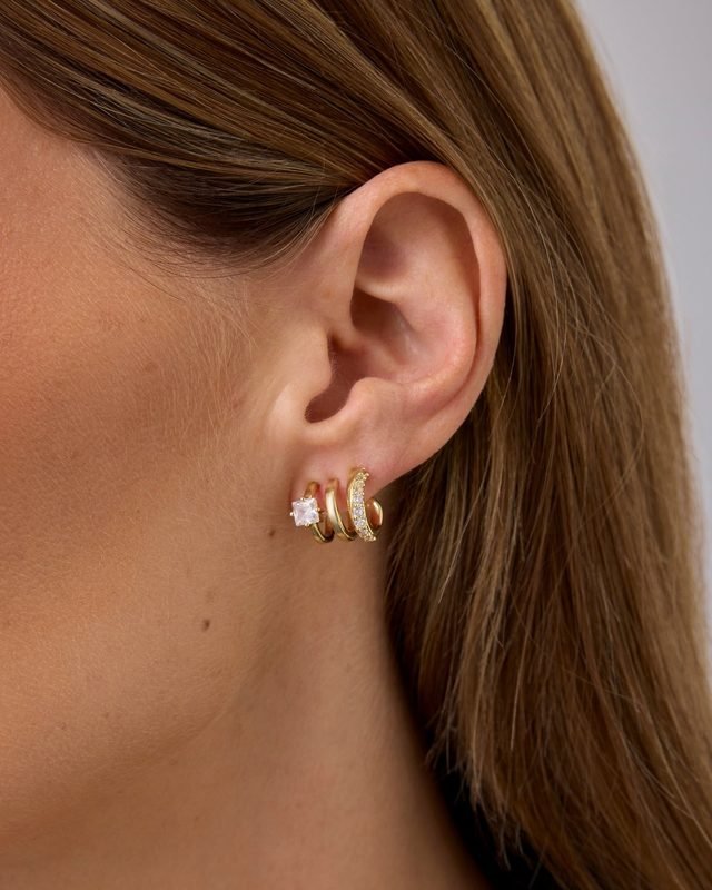 Gold-tone huggies in an ear stack